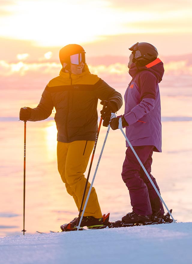 Homme et femme qui pratiquent du ski alpin avec des vêtements d'extérieur