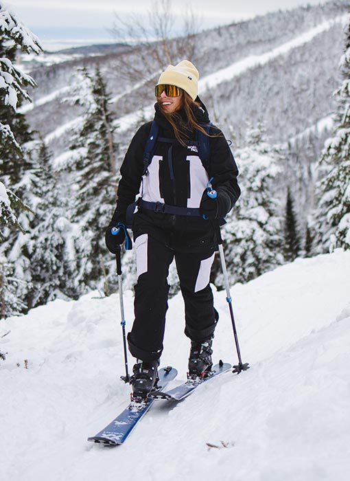 Femme qui pratique du ski de randonnée alpine avec un manteau The North Face
