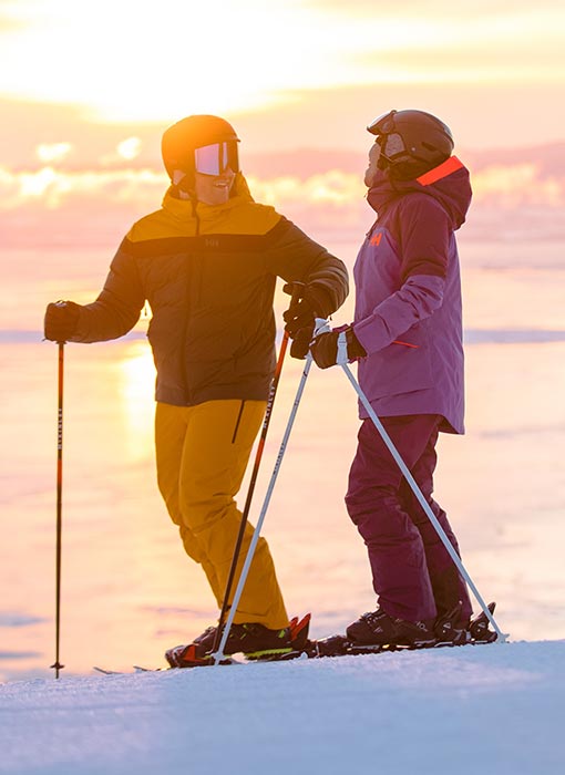 Homme et femme qui pratiquent du ski alpin avec des vêtements d'extérieur