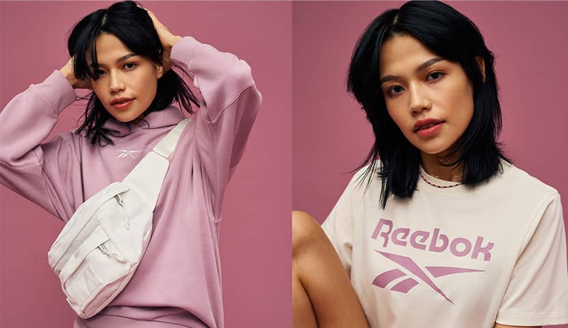 Jeune femnme qui porte un hoodie reebok rose et un tshirt reebok