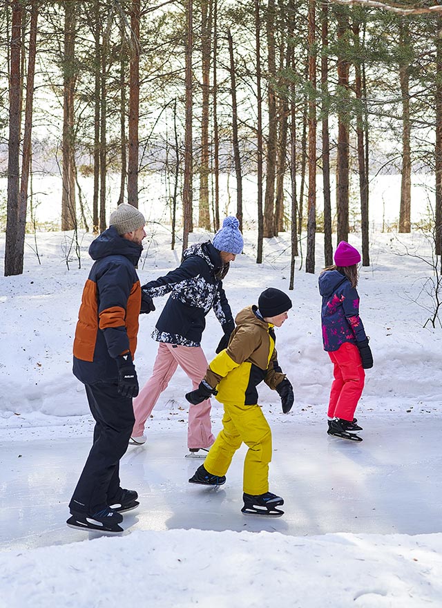 Famille qui fait du patin à glace sur une piste extérieure