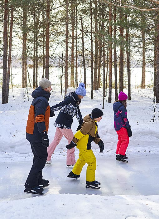 Famille qui fait du patin à glace sur une piste extérieure