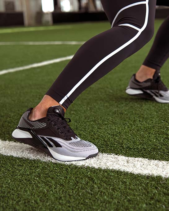 Personne qui s'entraîne avec un legging et des chaussures de course reebok
