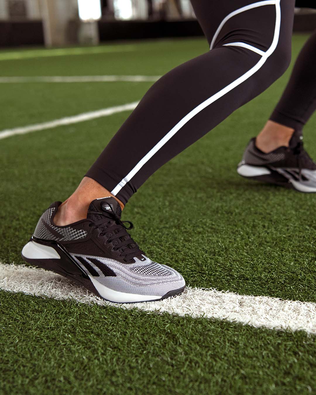 Personne qui s'entraîne avec un legging et des chaussures de course reebok