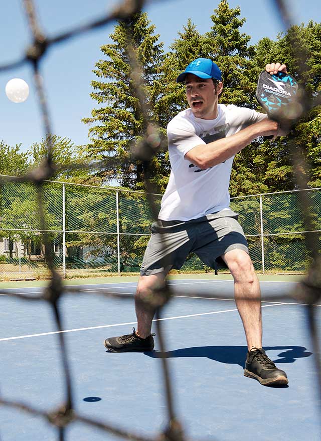 Homme qui joue au pickleball à l'extérieur