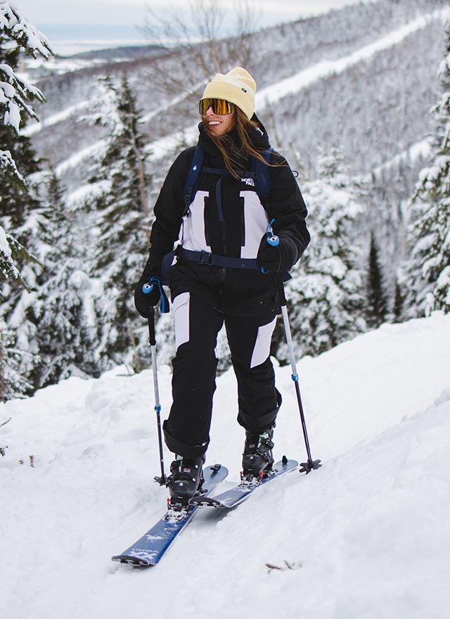 Femme qui pratique du ski de randonnée alpine avec un manteau The North Face